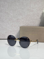 Gold-rim round sunglasses with dark navy tinted lenses and slim metal temples.