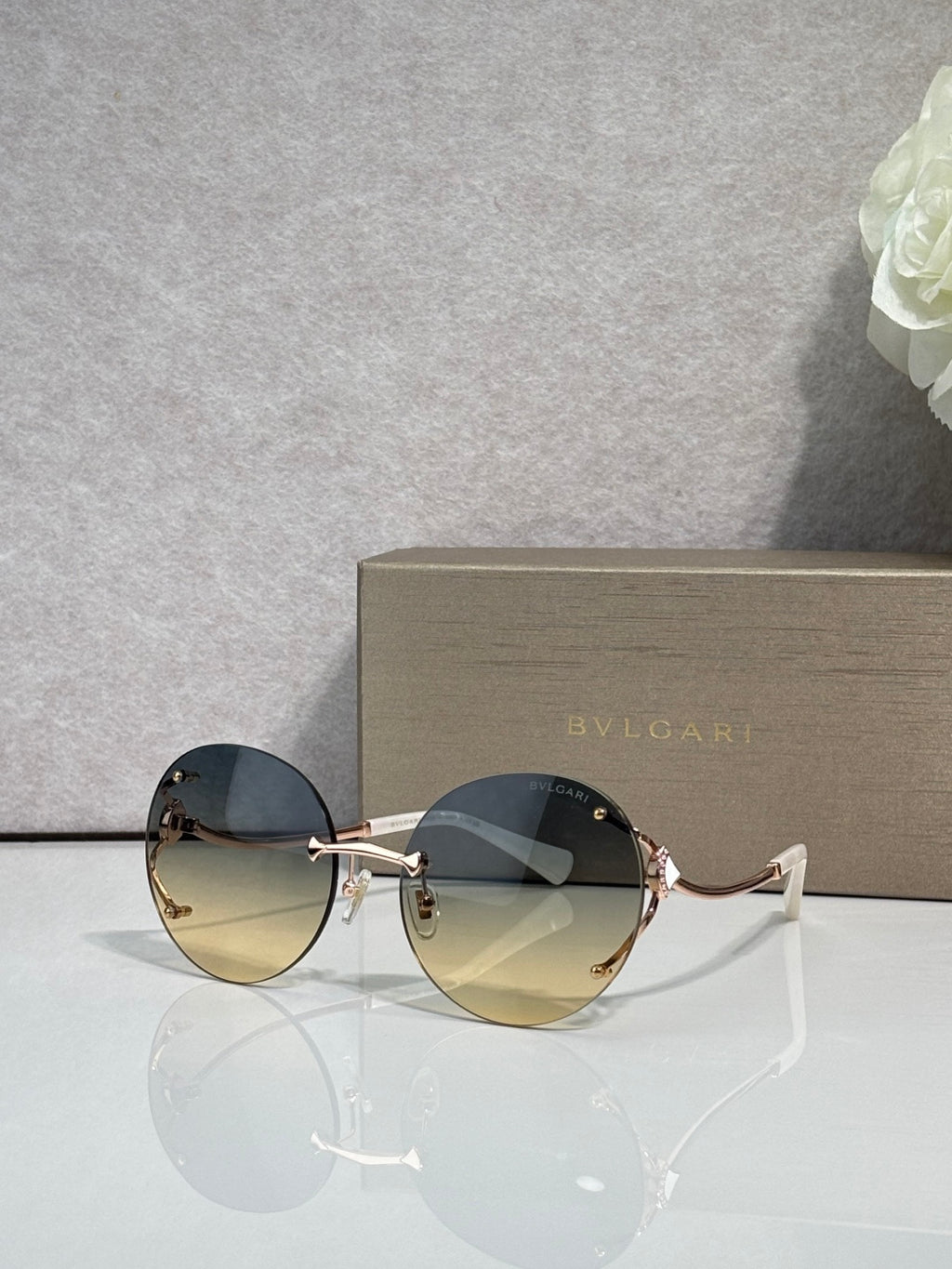 Gold-rim round sunglasses with dark blue gradient lenses and curved metal temples.