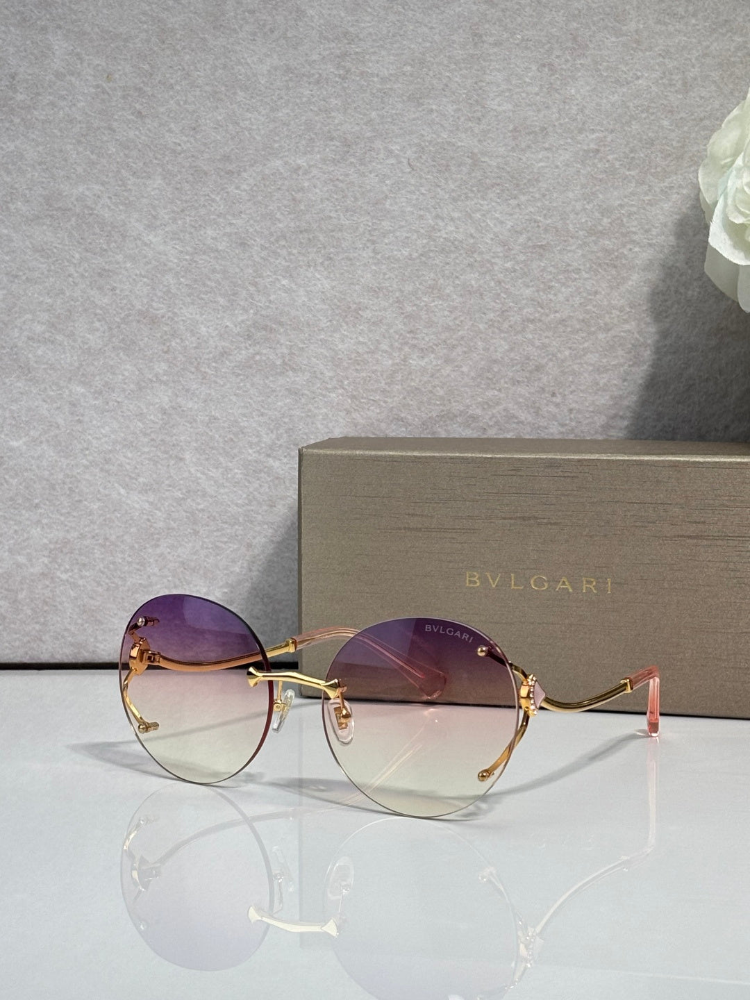 Gold-rim round sunglasses with purple gradient lenses and slim metal temples.