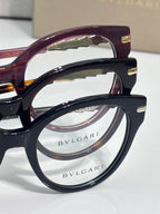 Bvlgari eyeglasses close-up: burgundy and black frames with Bvlgari logo lens rims