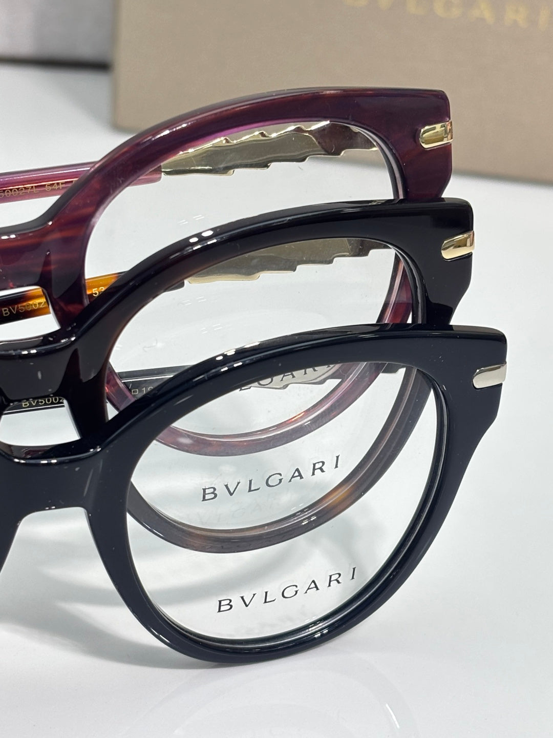 Bvlgari eyeglasses close-up: burgundy and black frames with Bvlgari logo lens rims