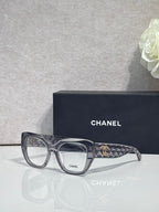Eyeglasses with gray frames, dark tortoiseshell temple, and gold Chanel logo detail.