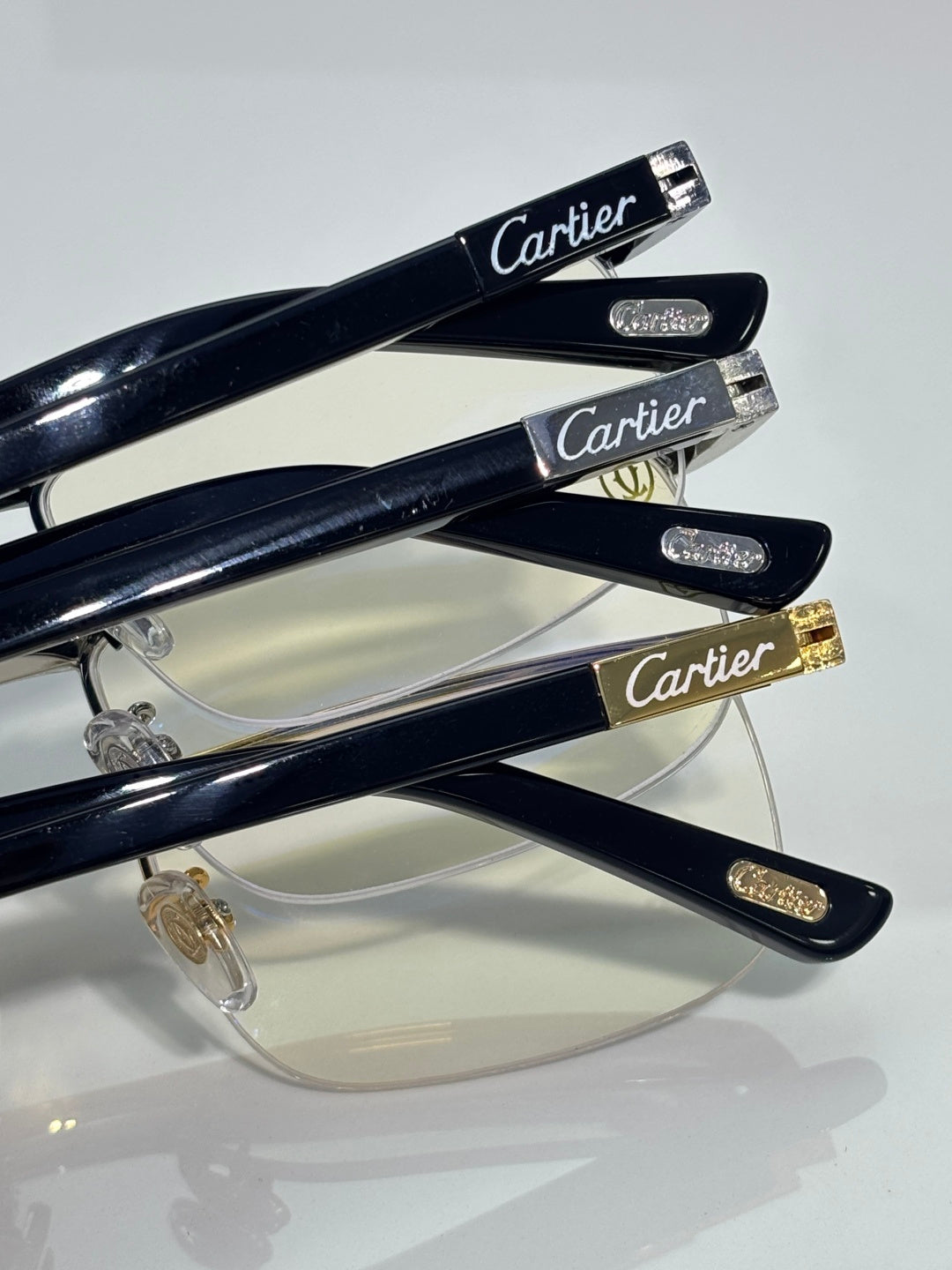 Cartier eyeglasses stack showing dark temples and clear lenses with gold accents