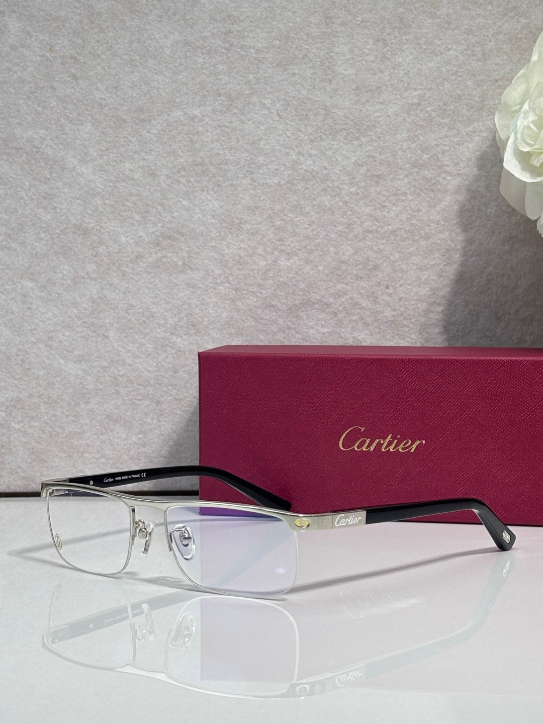 Cartier eyeglasses with dark frames, clear lenses, and gold bridge detail