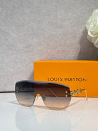 Louis Vuitton sunglasses with dark gradient lenses and gold chain link detail