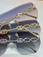 Louis Vuitton sunglasses close-up with gold chain bar over dark lenses