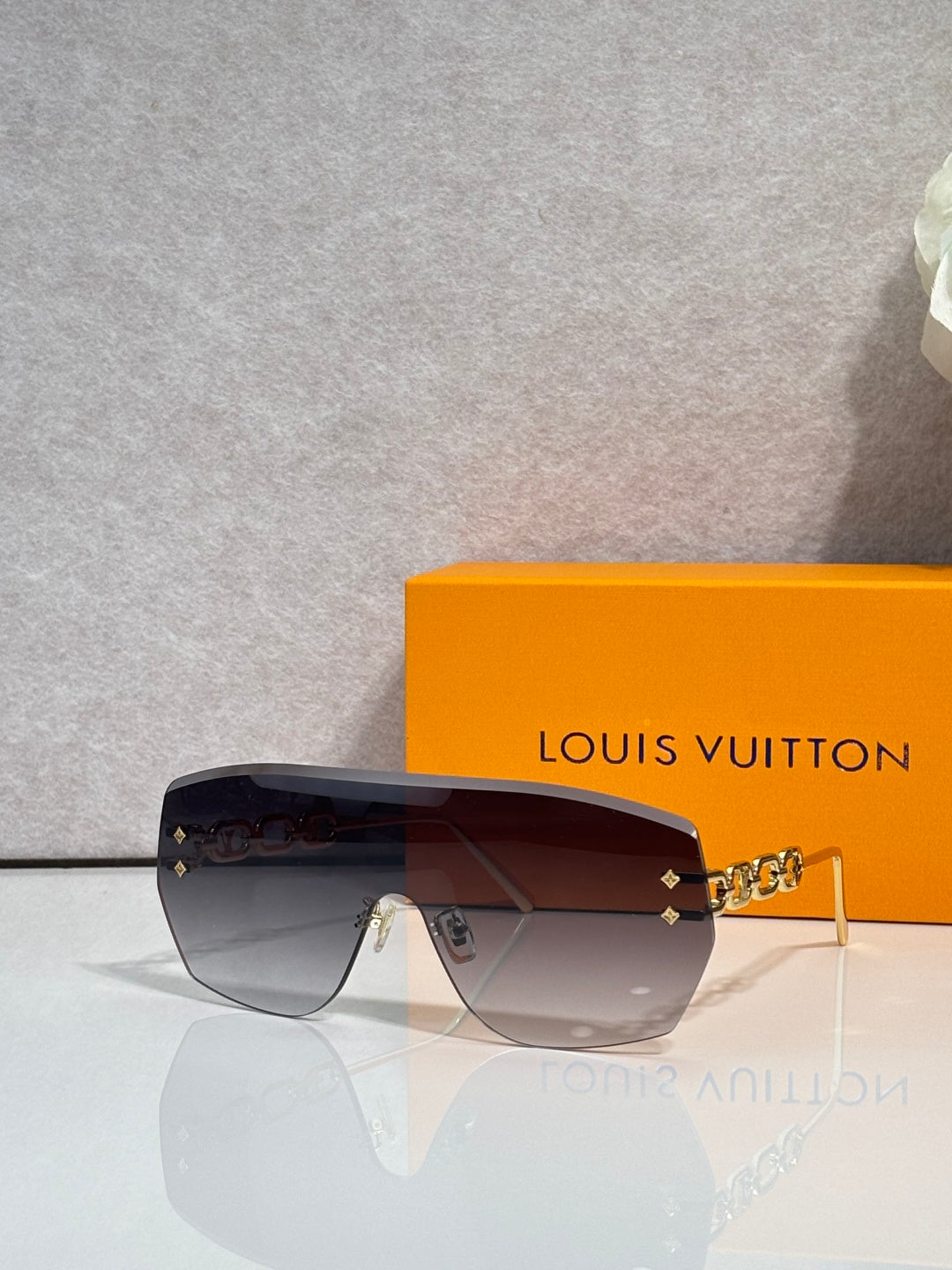 Louis Vuitton sunglasses with dark gradient lenses and tortoiseshell front with gold chain