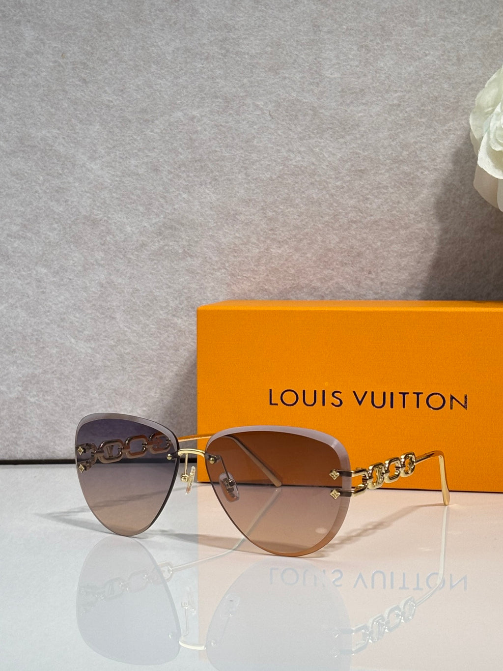 Louis Vuitton sunglasses with amber gradient lenses, gold frame and chain temples
