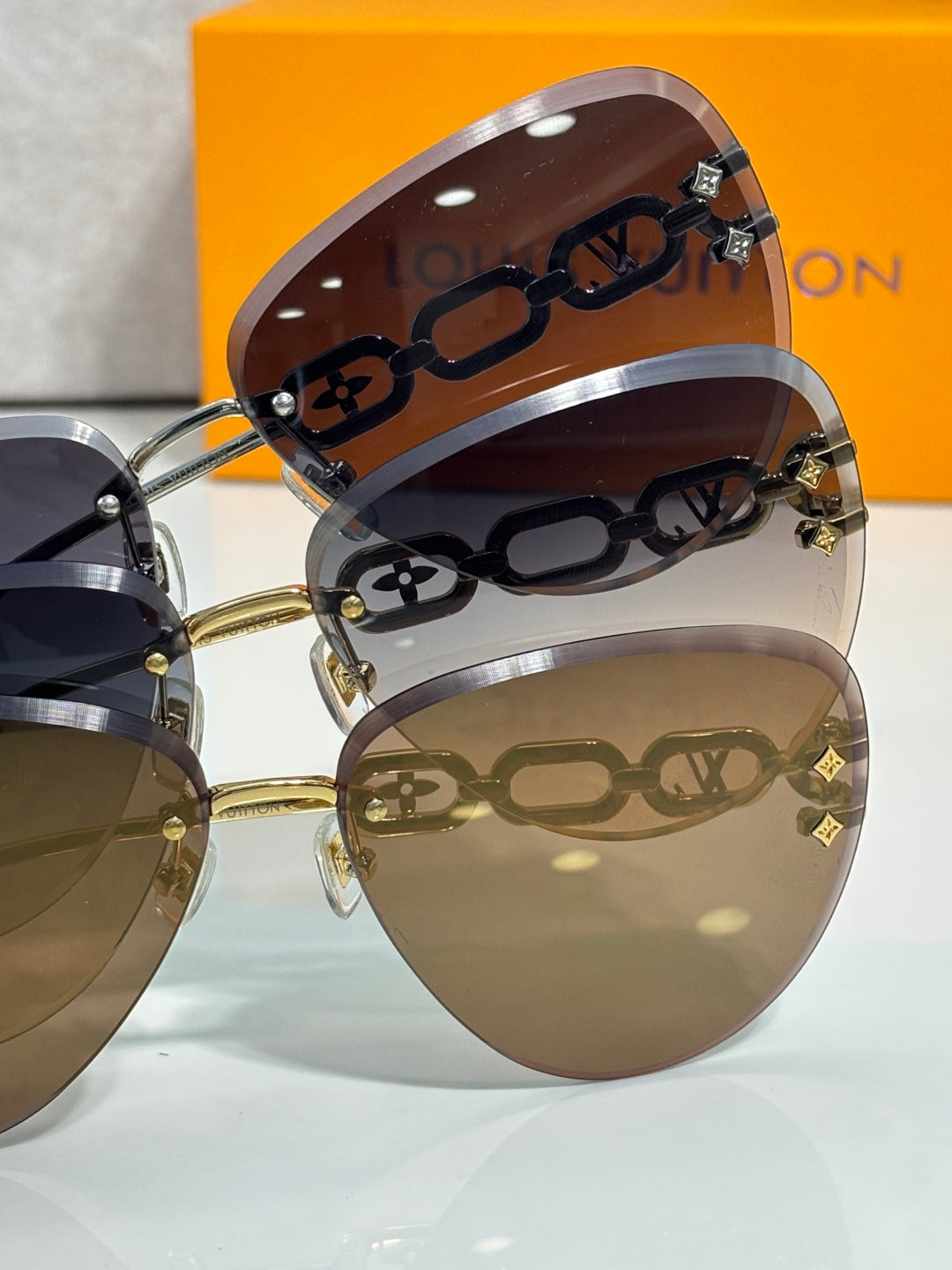 Louis Vuitton sunglasses close-up, monogram temple, gold hinges, tinted gradient lenses