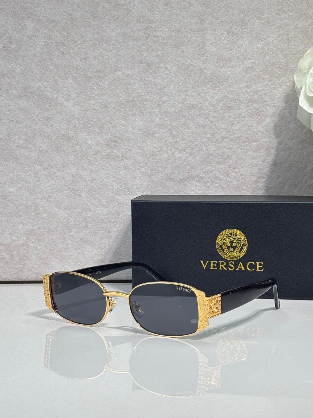 Versace glasses with gold frame, dark lenses, and black temples