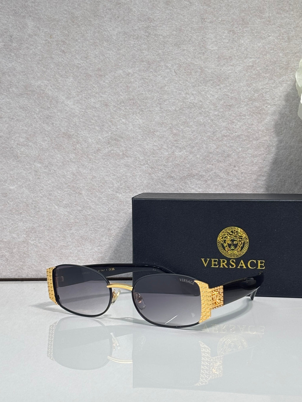 Versace glasses with black frame and dark lenses, gold patterned side details