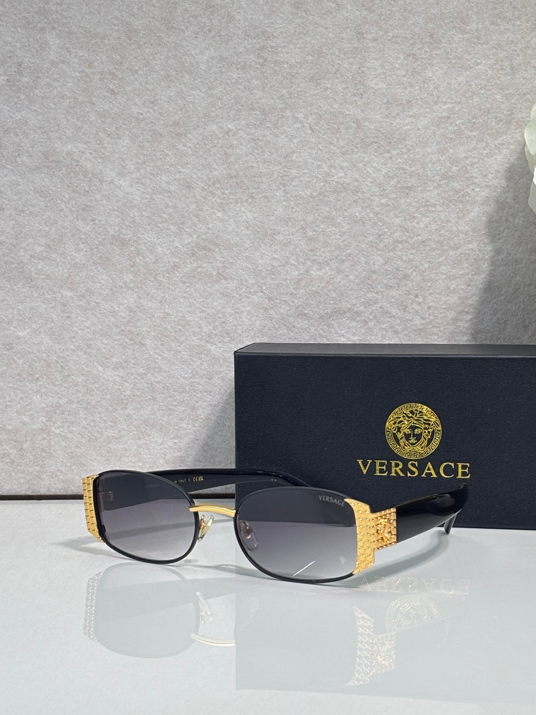 Versace glasses with black frame and dark lenses, gold patterned side details