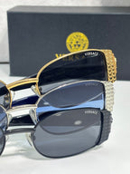 Versace glasses close-up with gold and silver frames and blue-tinted lenses