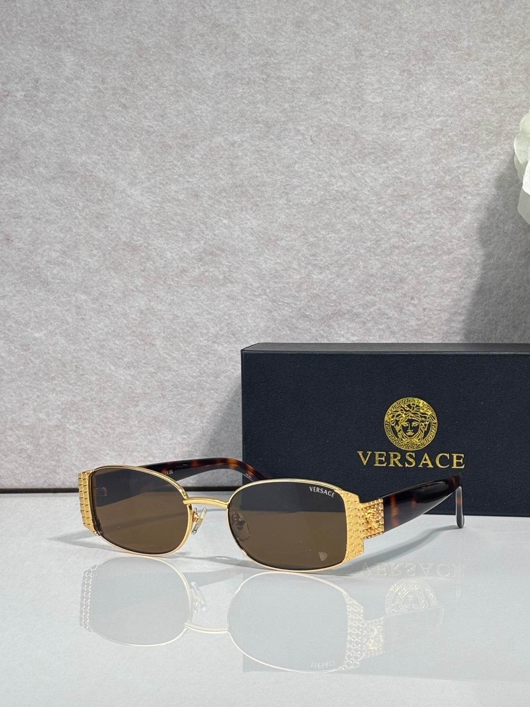Versace glasses with gold frame, dark brown lenses, and tortoiseshell temples