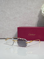 Cartier eyeglasses with gold-tone metal frame and rose-tinted lenses, side angle.