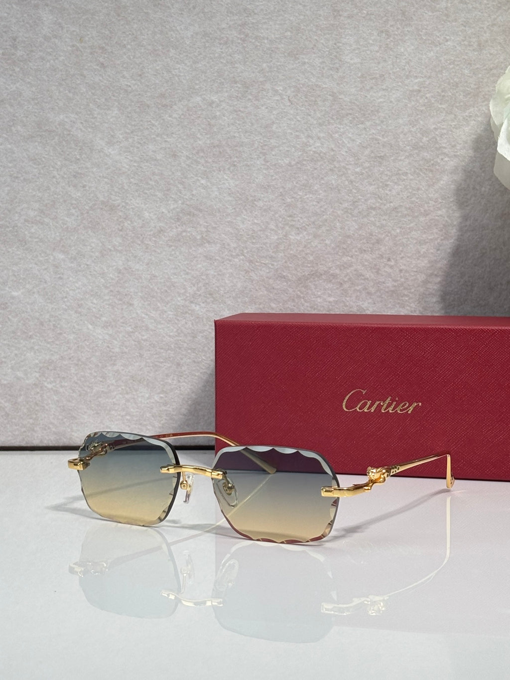 Cartier eyeglasses with gold-tone metal frame and amber-tinted lenses, angled view.