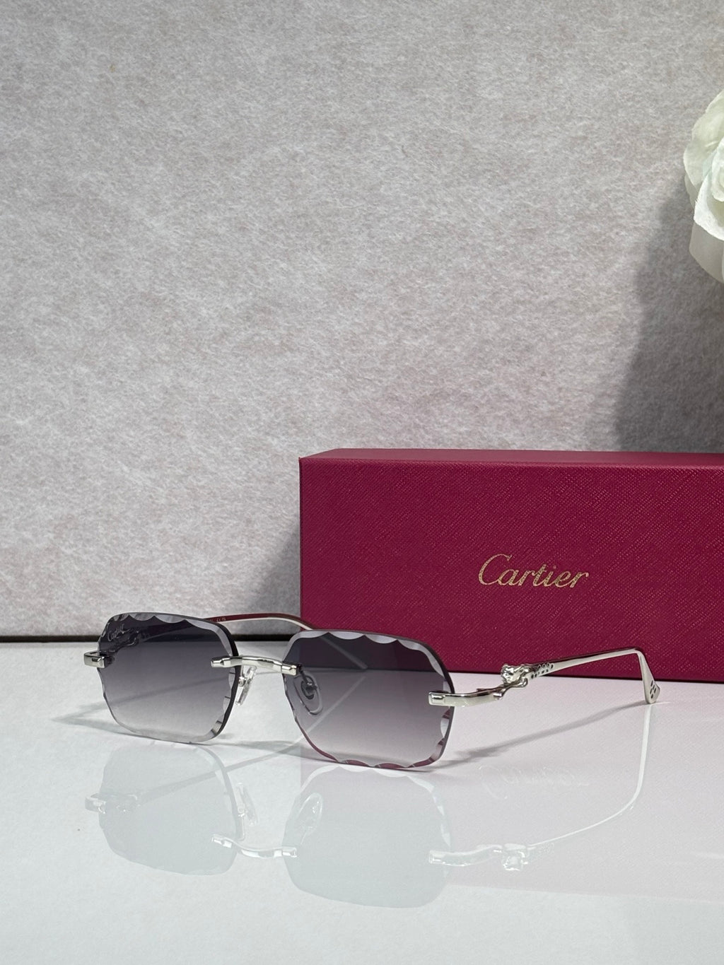 Cartier eyeglasses with gold-tone metal frame and dark smoked lenses, front view.