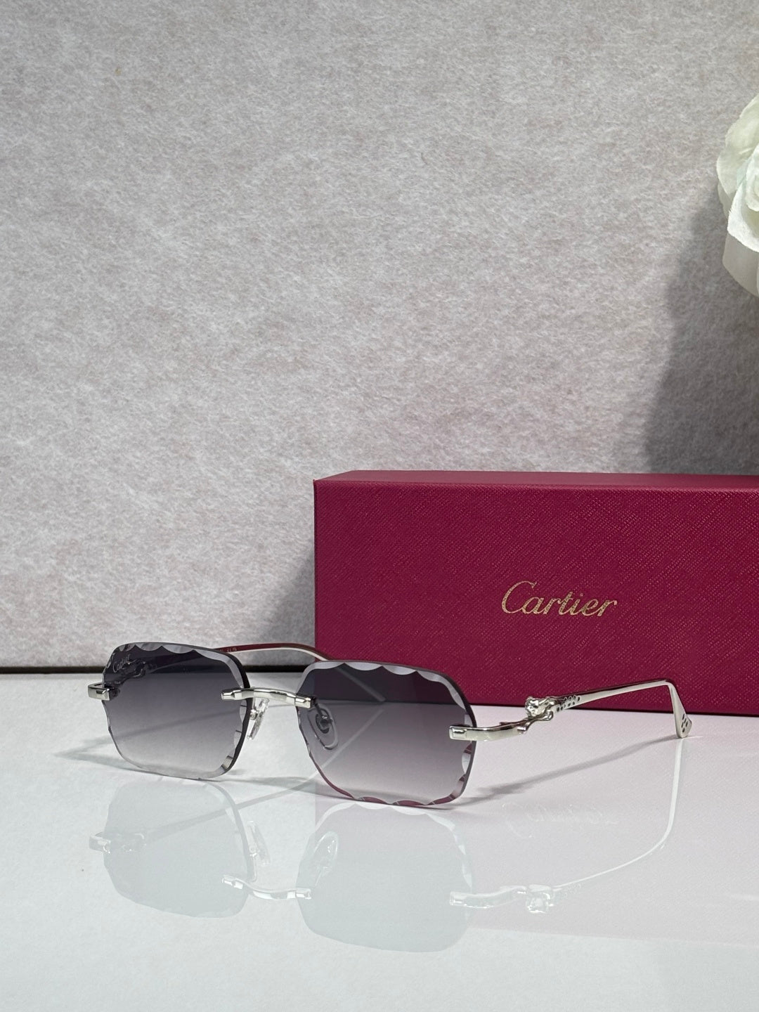 Cartier eyeglasses with gold-tone metal frame and dark smoked lenses, front view.