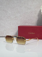 Cartier eyeglasses with gold-tone metal frame and amber gradient lenses, front view.