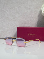 Gold-tone eyeglasses with light pink tinted lenses and decorative temple detailing.