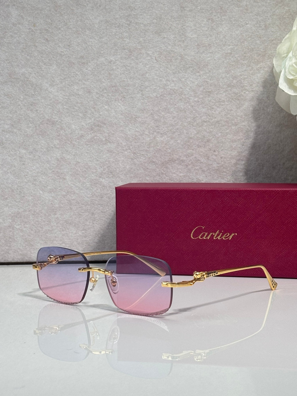 Cartier eyeglasses with gold-tone metal frame and tinted lenses, front view with reflections
