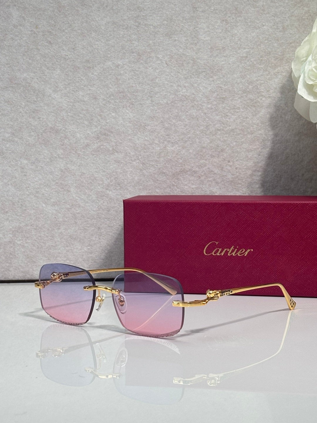 Cartier eyeglasses with gold-tone metal frame and tinted lenses, front view with reflections