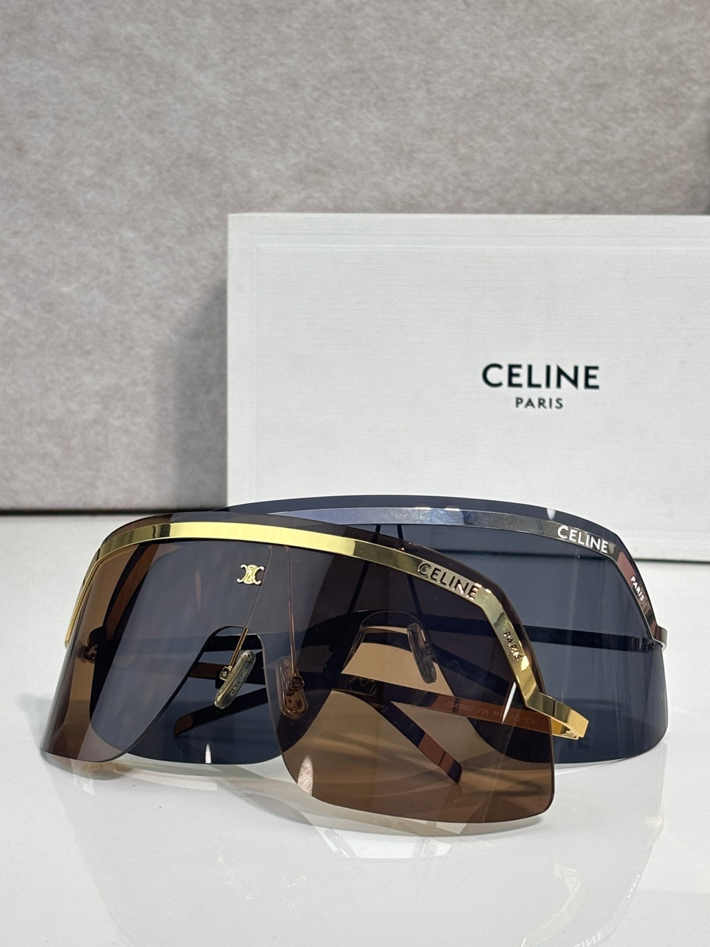 Celine sunglasses with dark blue lenses and gold-tone rim, oversized shield frame
