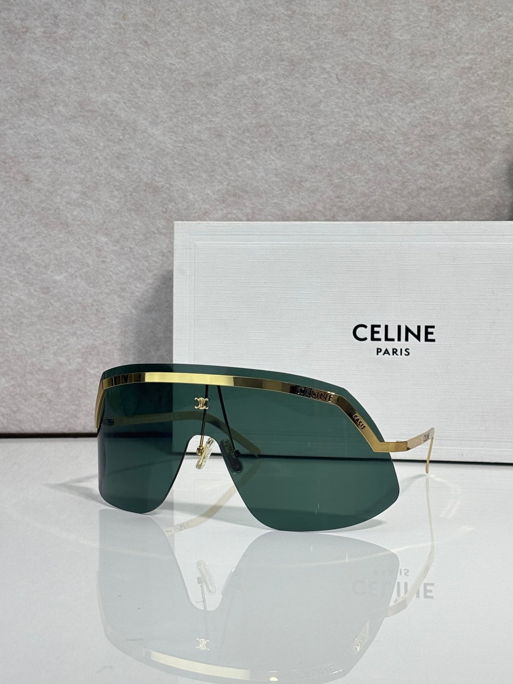 Celine sunglasses with green-tinted lenses and gold-toned metal frame, oversized shield