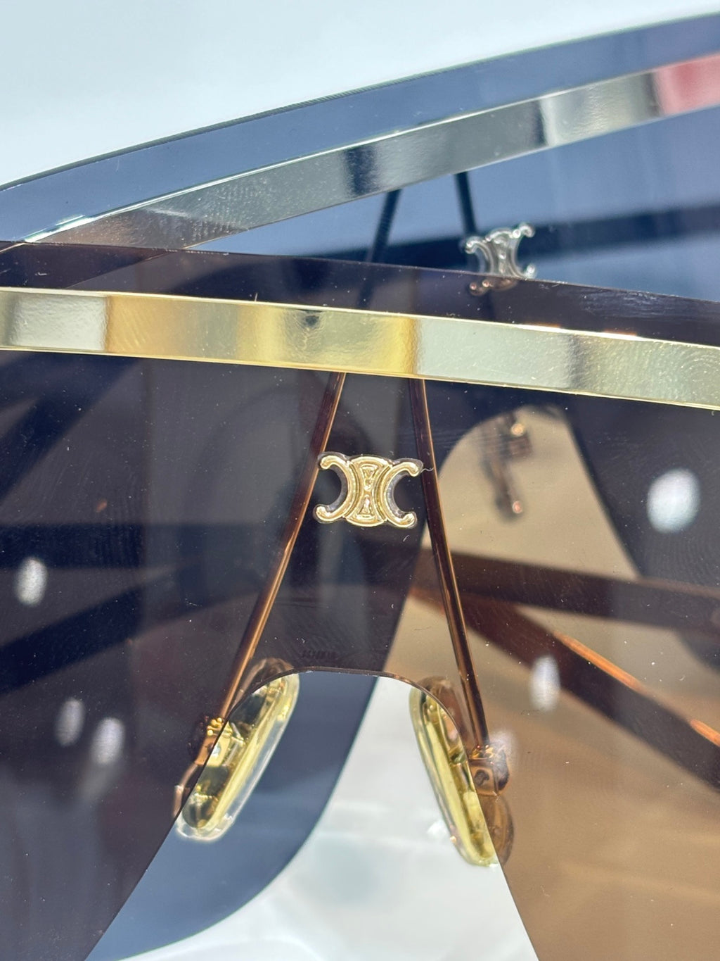 Celine sunglasses close-up of shield lens and gold metal temple arms with logo