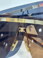 Celine sunglasses close-up of shield lens and gold metal temple arms with logo