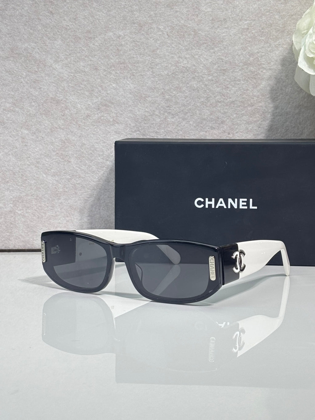 Chanel sunglasses with dark frames and white arms, rectangular lenses