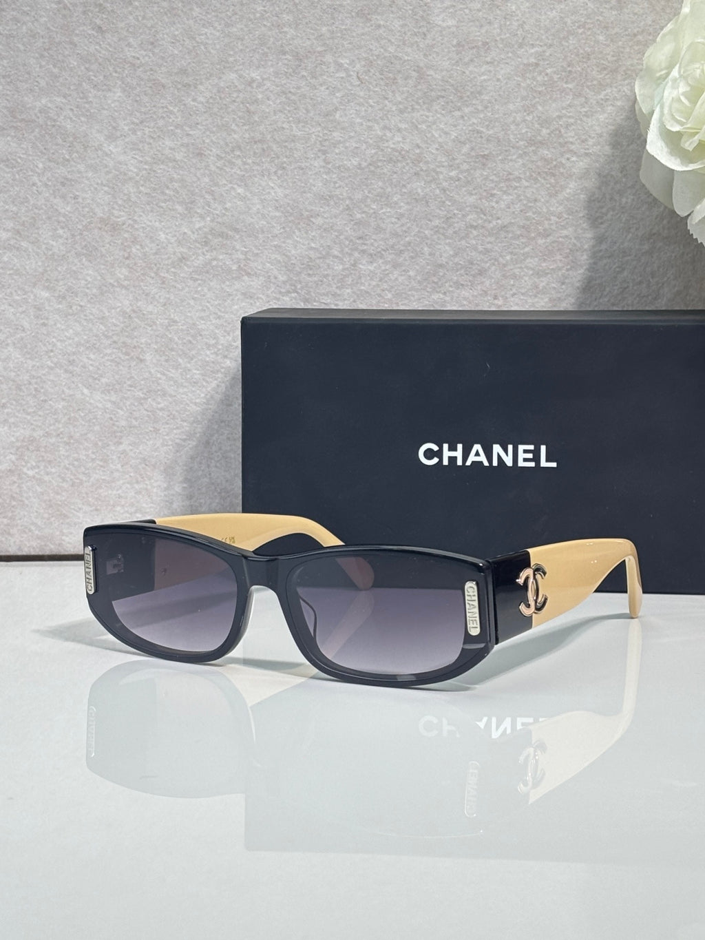 Chanel sunglasses with dark frames, cream arms, rectangular lenses