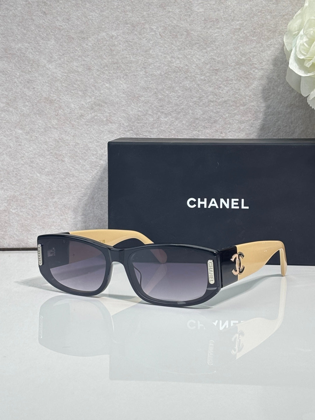 Chanel sunglasses with dark frames, cream arms, rectangular lenses