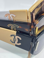 Chanel sunglasses close-up with engraved CC logo on dark and gold arms