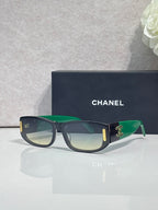 Chanel sunglasses with dark frames, green arms, rectangular lenses