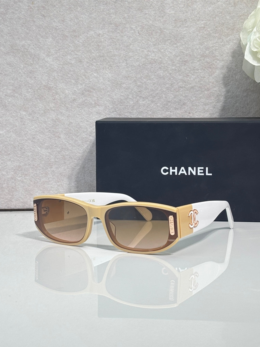 Chanel sunglasses with light frames, tan arms, rectangular lenses