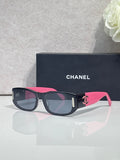 Chanel sunglasses with dark frames, pink arms, rectangular lenses