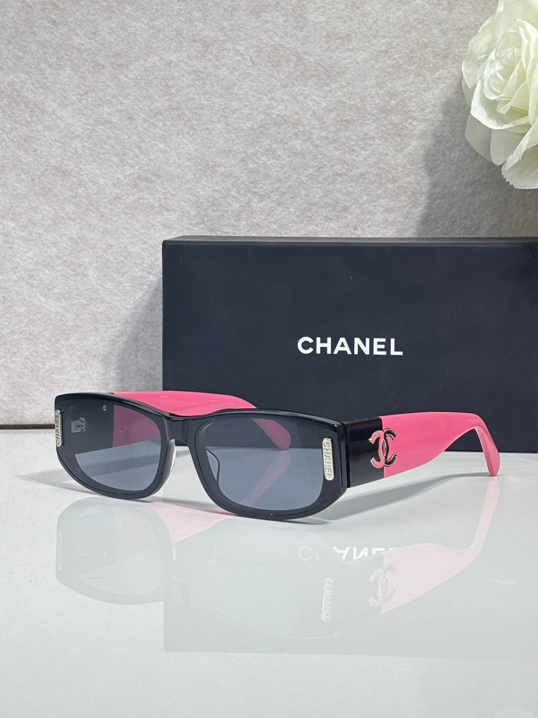 Chanel sunglasses with dark frames, pink arms, rectangular lenses
