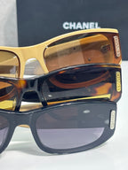 Chanel sunglasses close-up with amber lens and gold-toned frame with CC logo