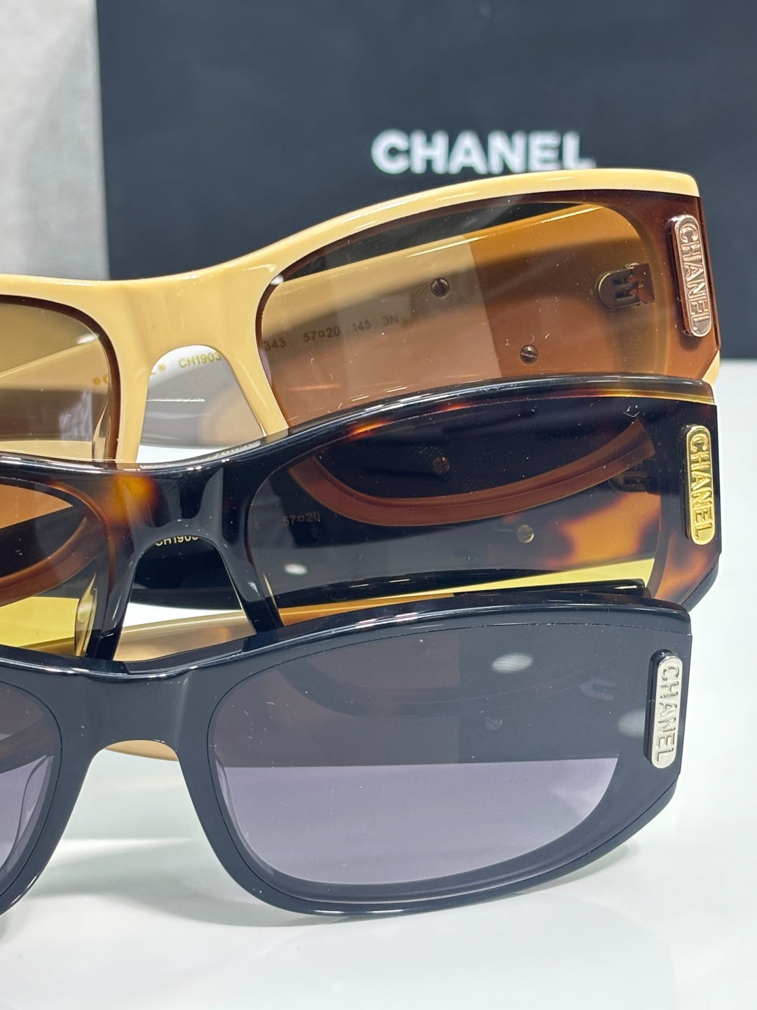 Chanel sunglasses close-up with amber lens and gold-toned frame with CC logo