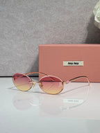 MiuMiu round sunglasses with pink lenses, gold-toned metal frame, logo on temples