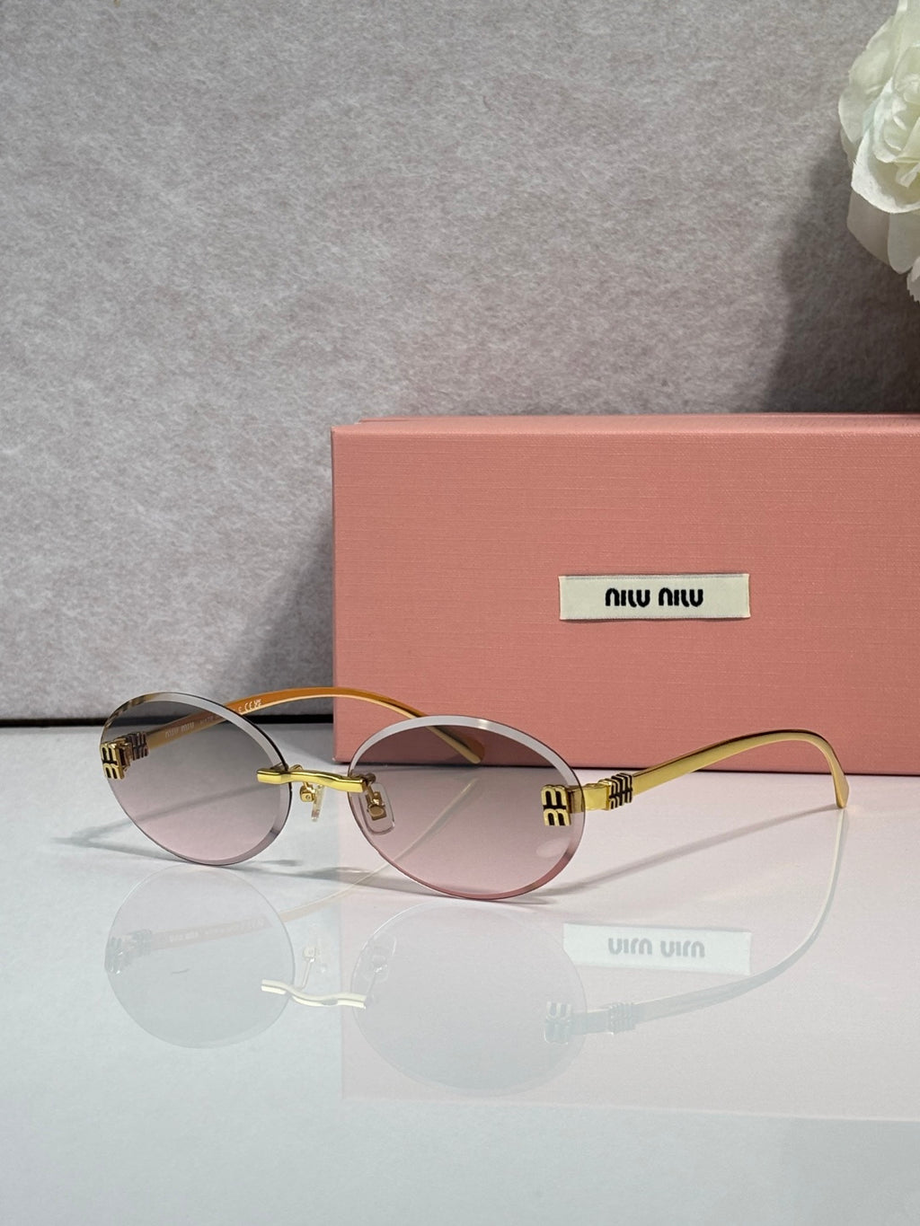 MiuMiu round sunglasses with light tinted lenses, gold-toned frame, logo on temples