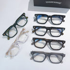Assorted eyeglass frames in green, clear, blue, and dark tones with clear lenses