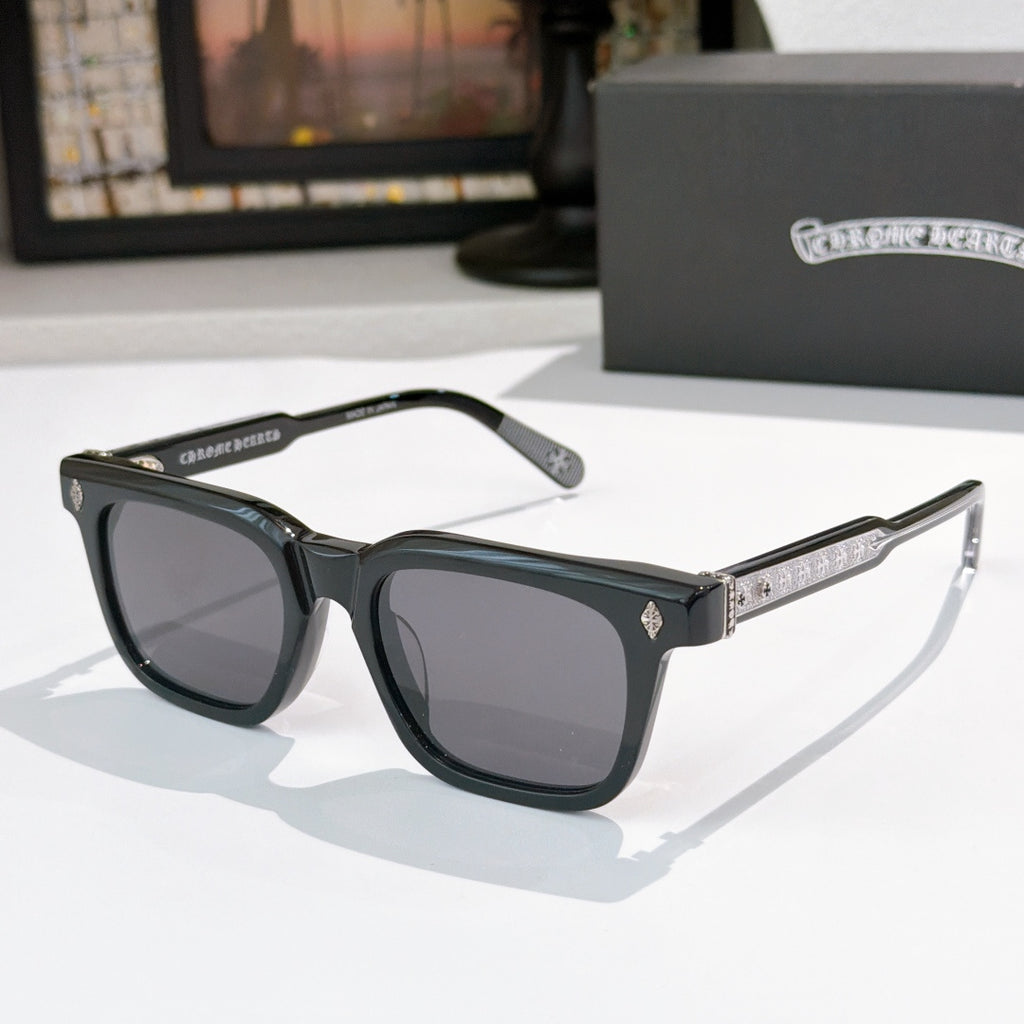 Chrome glasses with black frames and dark lenses, featuring patterned temple accents
