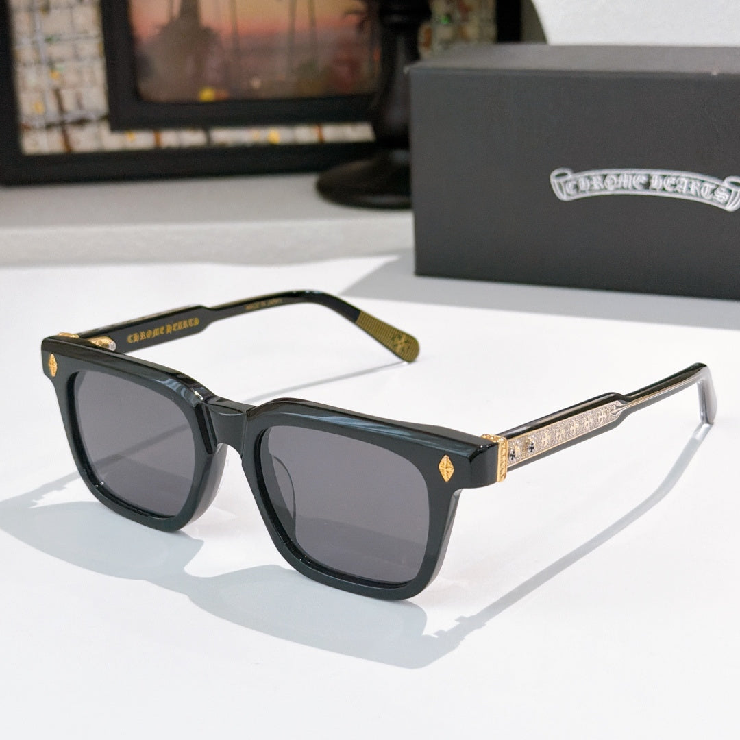 Chrome glasses with black frames, dark lenses, and gold temple detailing