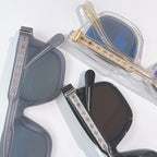 Chrome glasses close-up: clear frame with blue lenses and gold temple accents