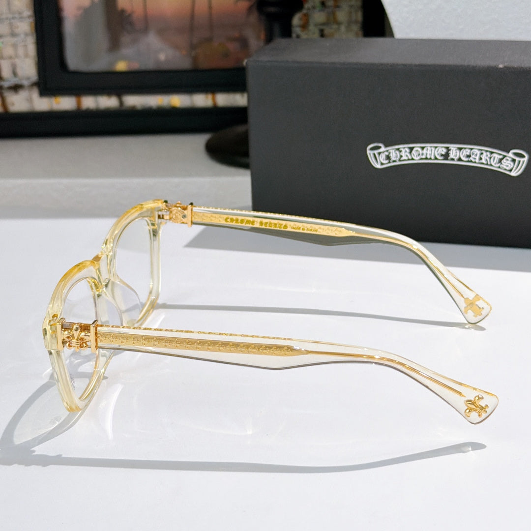 Clear-tinted eyeglasses with gold-tone temples and decorative side hardware