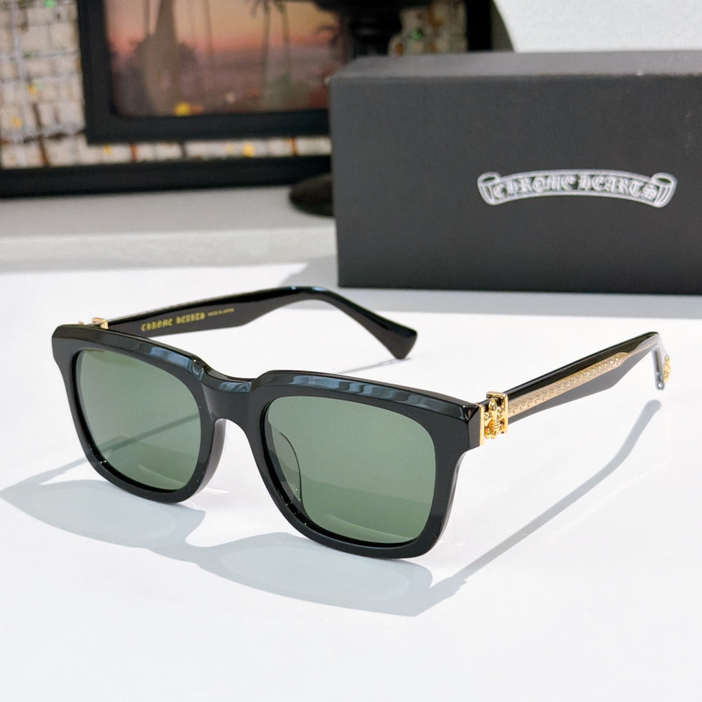 Black cat-eye sunglasses with green-tinted lenses and jeweled metal bridge
