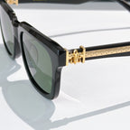 Black cat-eye sunglasses side view with gold-tone hinge and temple pattern