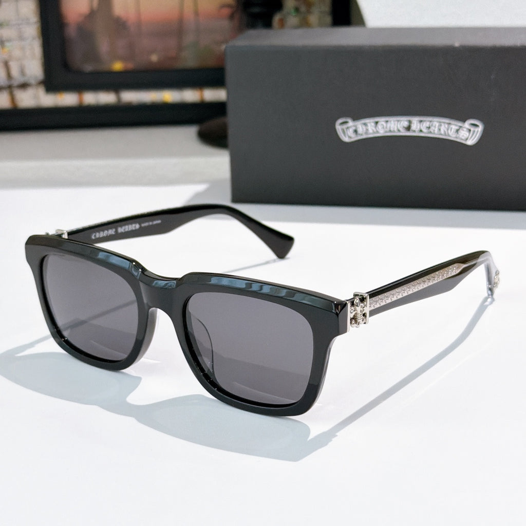 Black cat-eye sunglasses with gray lenses and jeweled metal bridge